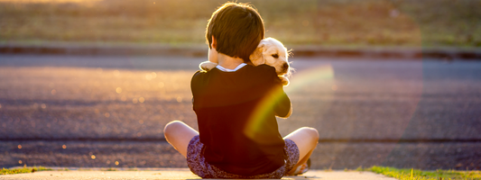 un enfant de dos tien un chiot dans ses bras